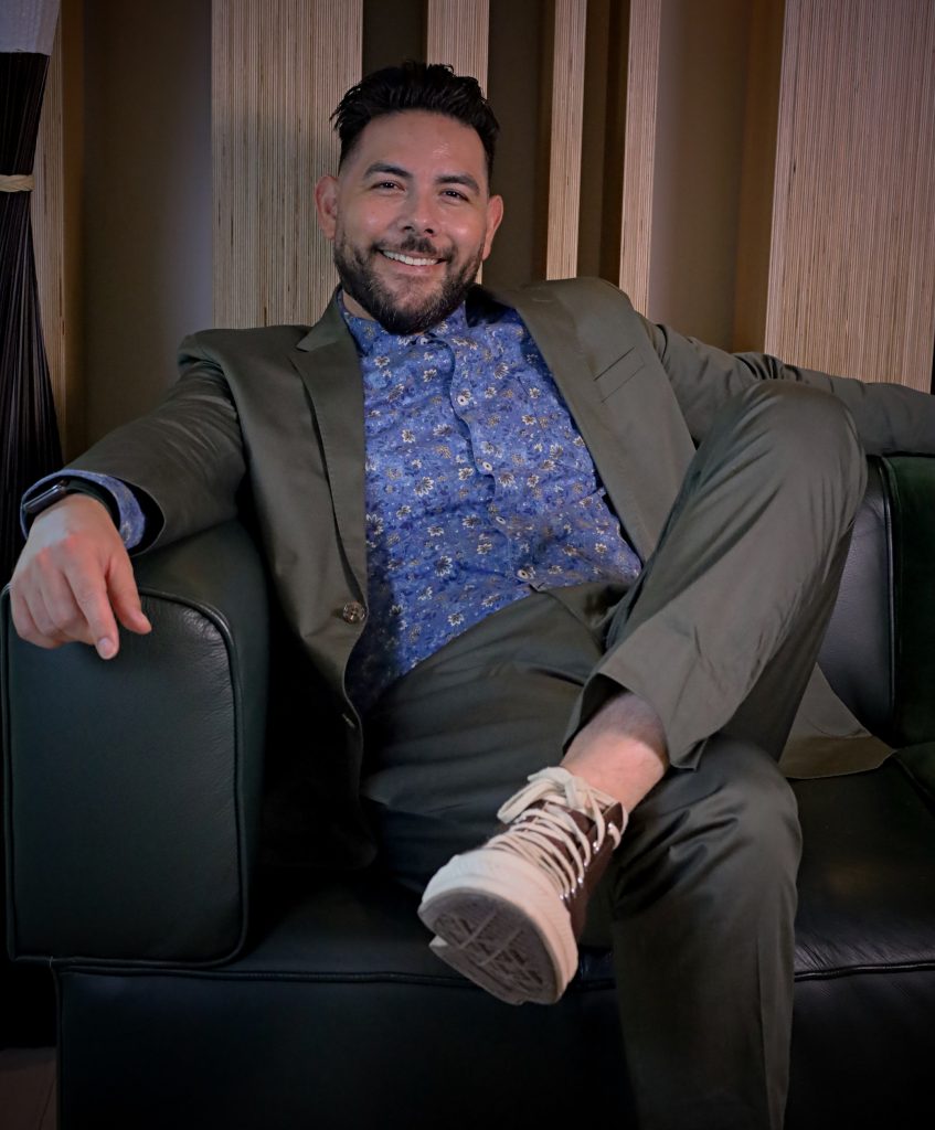 male therapist sitting on couch, smiling